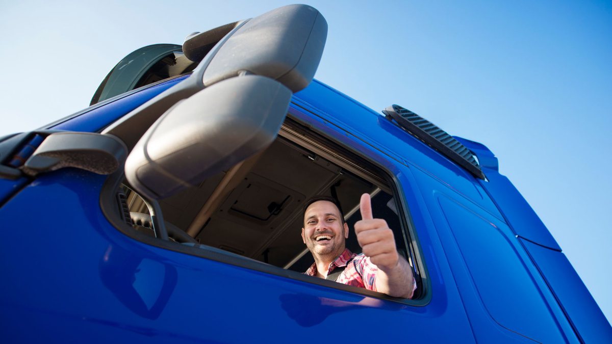Auxílio caminhoneiro: motorista de caminhão azul faz sinal de positivo com a mão - Divulgação