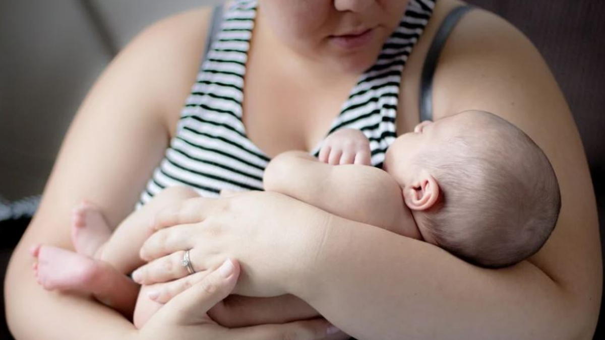 Uma mulher segura um bebê no colo - Divulgação - Auxílio Permanente para mães solteiras