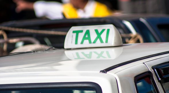 Um carro com a placa de táxi no teto - Canva - Auxílio taxista