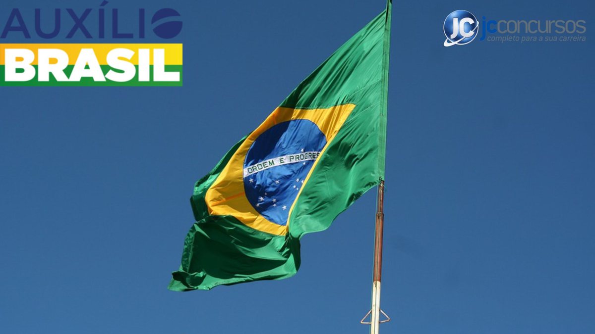 Uma bandeira do Brasil ao lado da logo do programa Auxílio Brasil