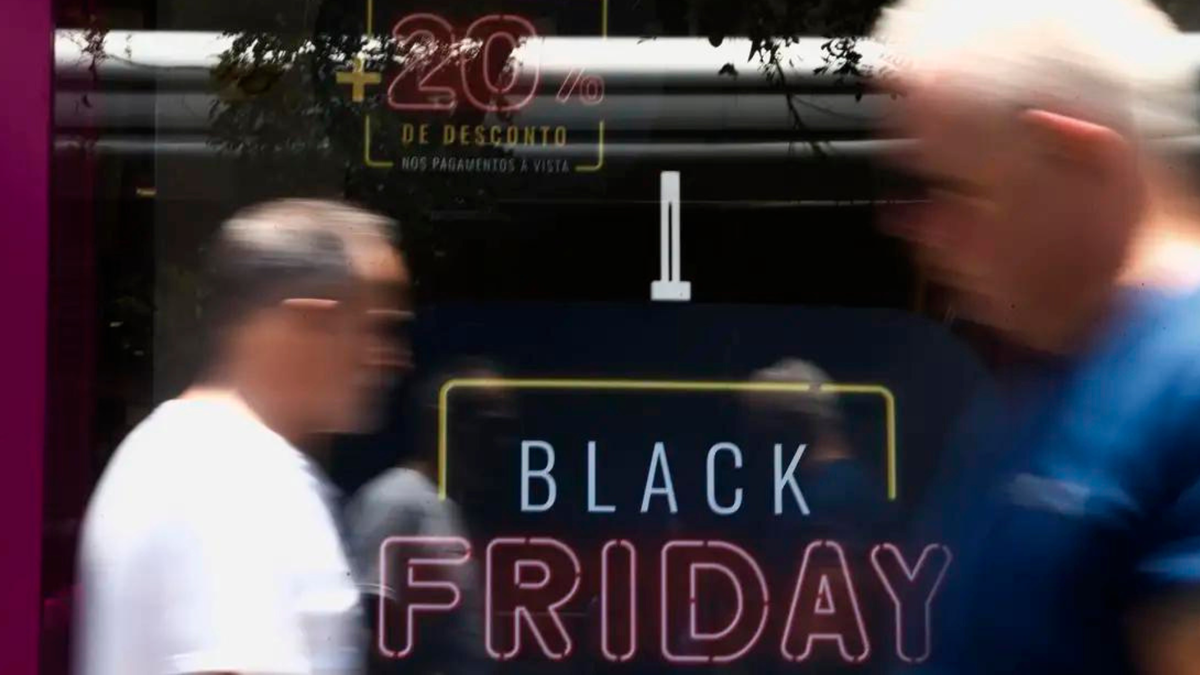 Pessoas passam por vitrine com promoção da Black Friday - Divulgação/Agência Brasil