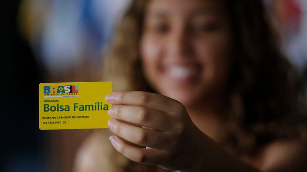 Uma mulher segura o cartão do programa de transferência de renda - Agência Brasil - Bolsa Família 2023