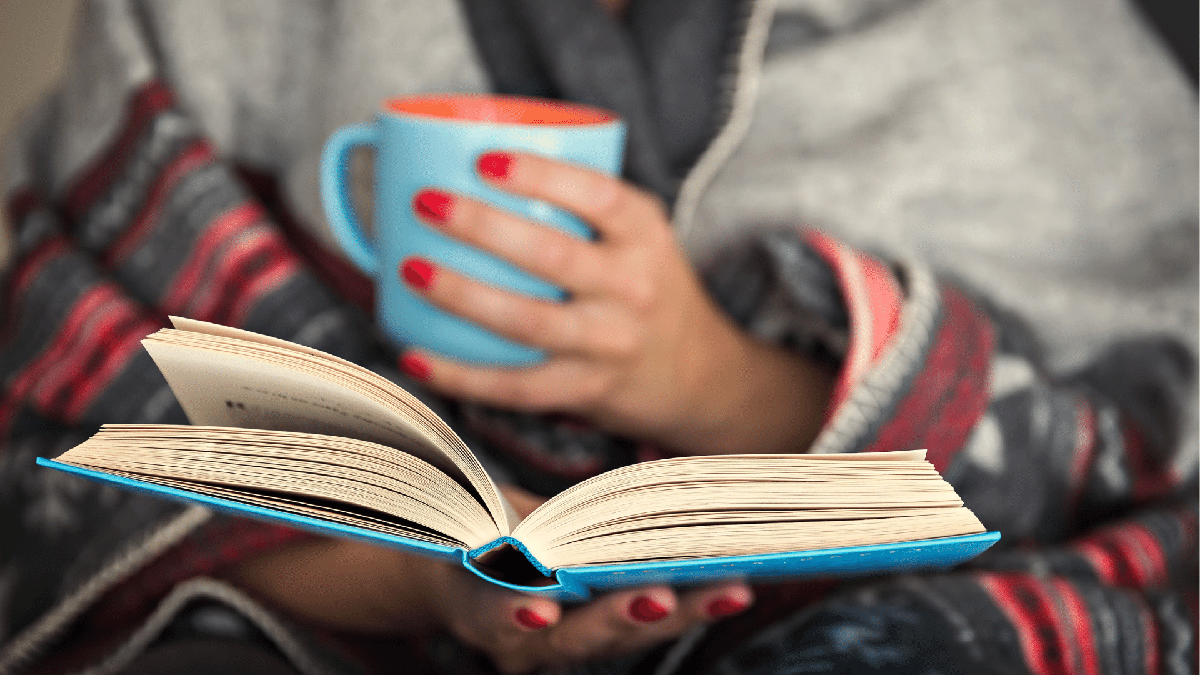 Brasileiros lendo mais: mulher faz leitura de livro enquanto toma café - Divulgação