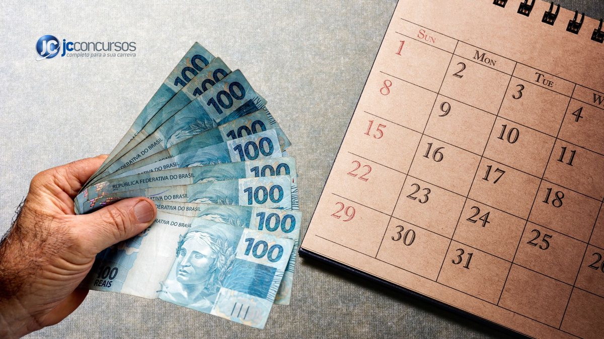 Homem segura notas de dinheiro ao lado de um calendário - Divulgação JC Concursos
