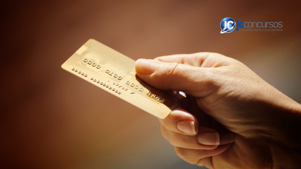 Uma mulher segura um cartão de crédito - Canva - Cartão corporativo