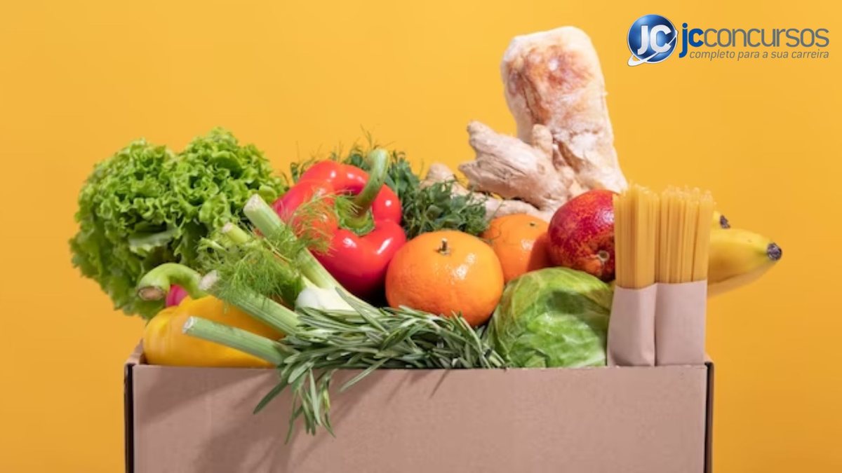 Frutas, legumes, verduras e macarrão dentro de caixa de papelção
