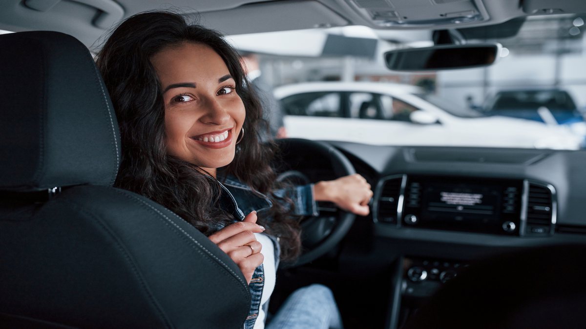 Redução do IPI: mulher sorri enquanto está na condução de automóvel - Divulgação
