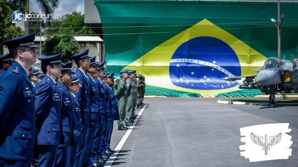 Concurso da Aeronáutica: militares perfilados com bandeira do Brasil e aeronave ao fundo - Divulgação