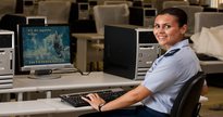 Concurso Aeronáutica: enquanto utiliza computador, aluna do curso de intendência da AFA posa para foto - Divulgação