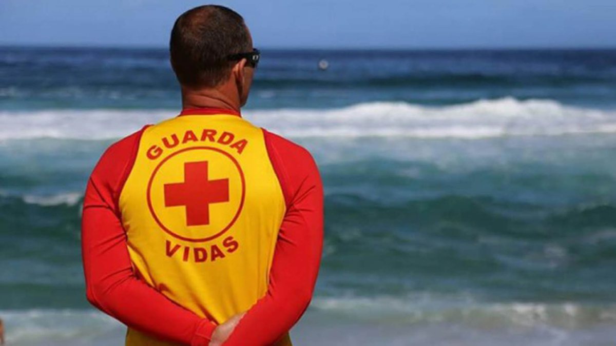 Processo Seletivo Prefeitura de Ilhabela: Guarda-Vidas olha praia com braços para trás - Divulgação