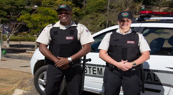 Concurso Depen MG: dois policiais penais posam para foto ao lado de viatura - Divulgação