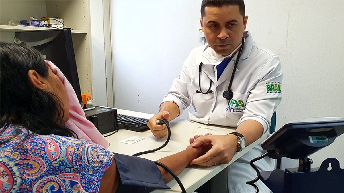 Concurso Funsaúde CE: mulher recebe atendimento médico em consultório