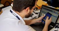 Concurso IBGE: servidor manuseia dispositivo móvel de coleta de dados - Divulgação