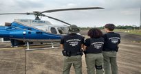 Concurso do ICMBio: servidores vistos de costas ao lado de helicóptero - Divulgação