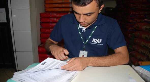 Concurso do Idaf ES: fiscal analisa documentos durante operação em loja de agrotóxicos - Divulgação