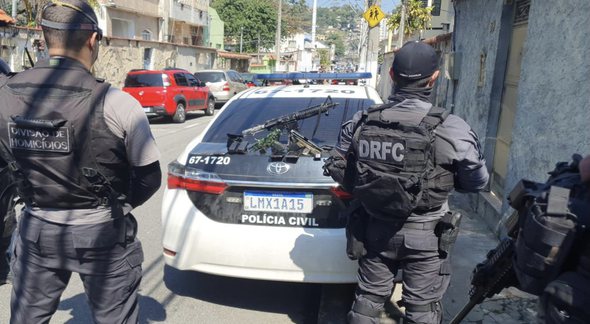 Concurso PC RJ: policiais aparecem de costas ao lado de viatura durante operação - Divulgação