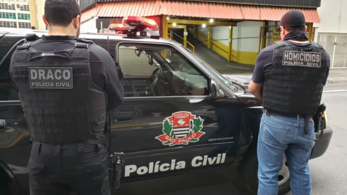 Policiais civis de São Paulo ao lado de viatura