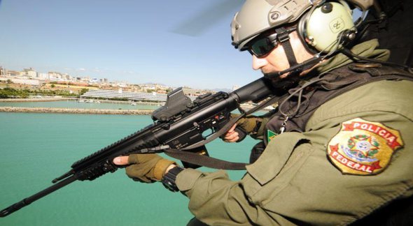 Concurso Polícia Federal: agente segura arma durante voo em helicóptero - Divulgação