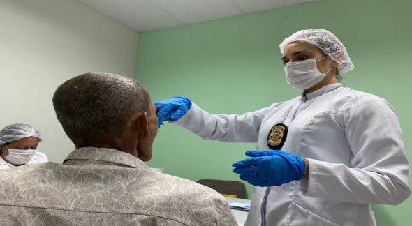 Concurso da Polícia Científica de Alagoas: perito coleta material genético de homem - Divulgação