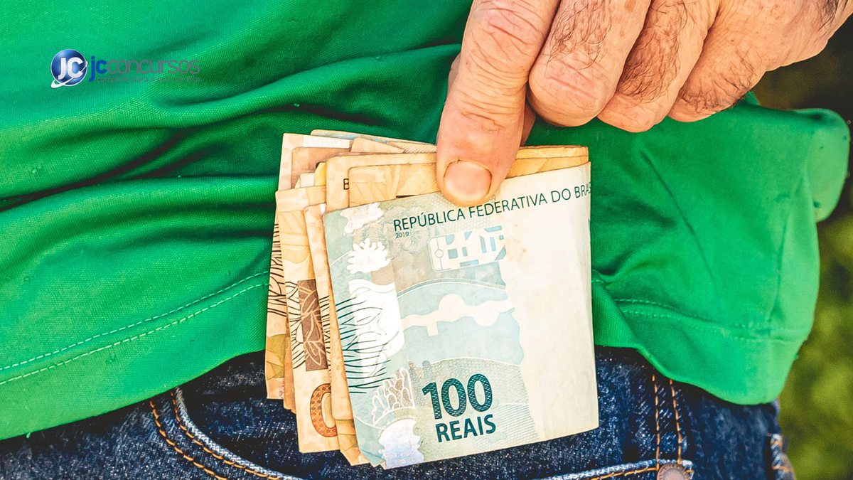 Homem coloca dinheiro no bolso da calça