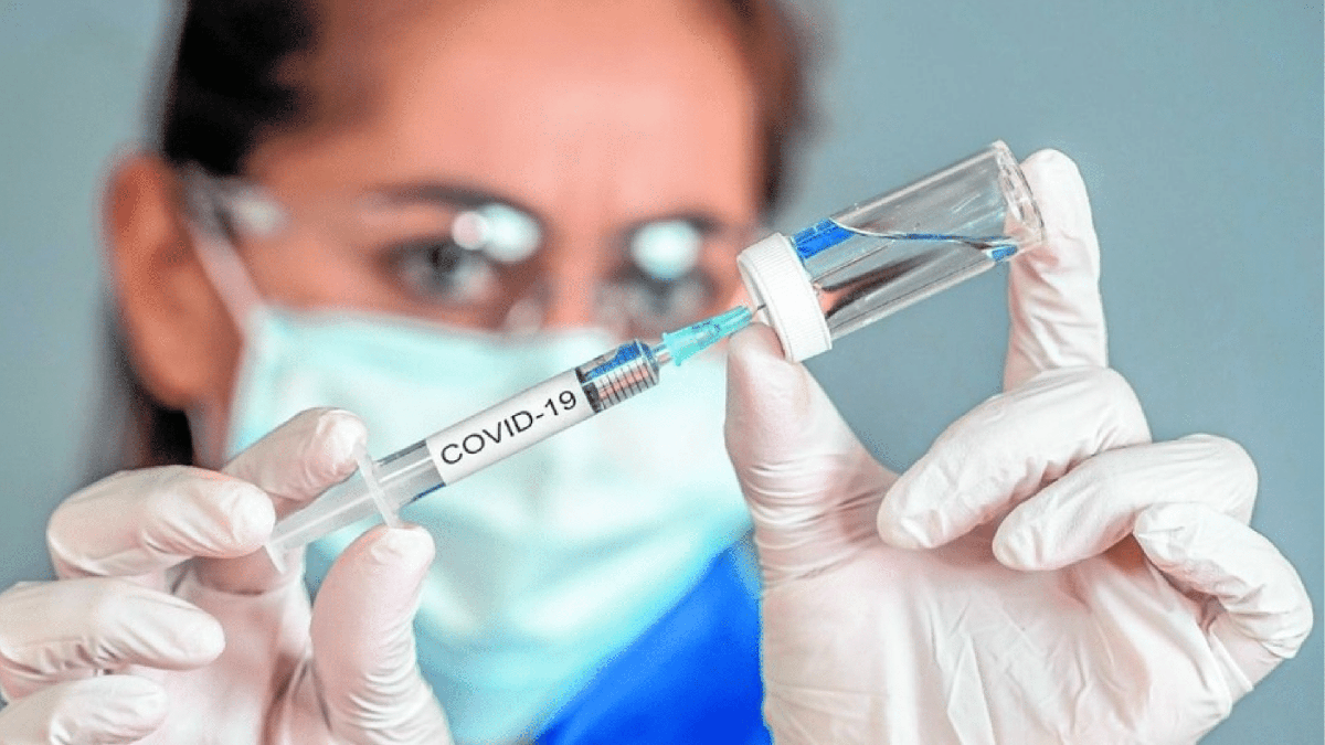 Mulher preenchendo seringa com imunizante contra Covid-19 - Divulgação