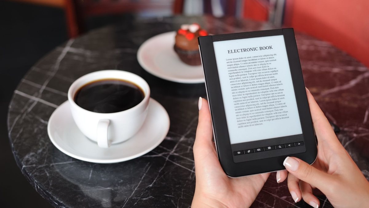 Ebook grátis: mulher lê livro digital enquanto toma café - Divulgação