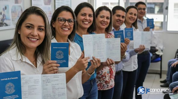 Trabalhadores segurando a carteira de trabalho nas mãos