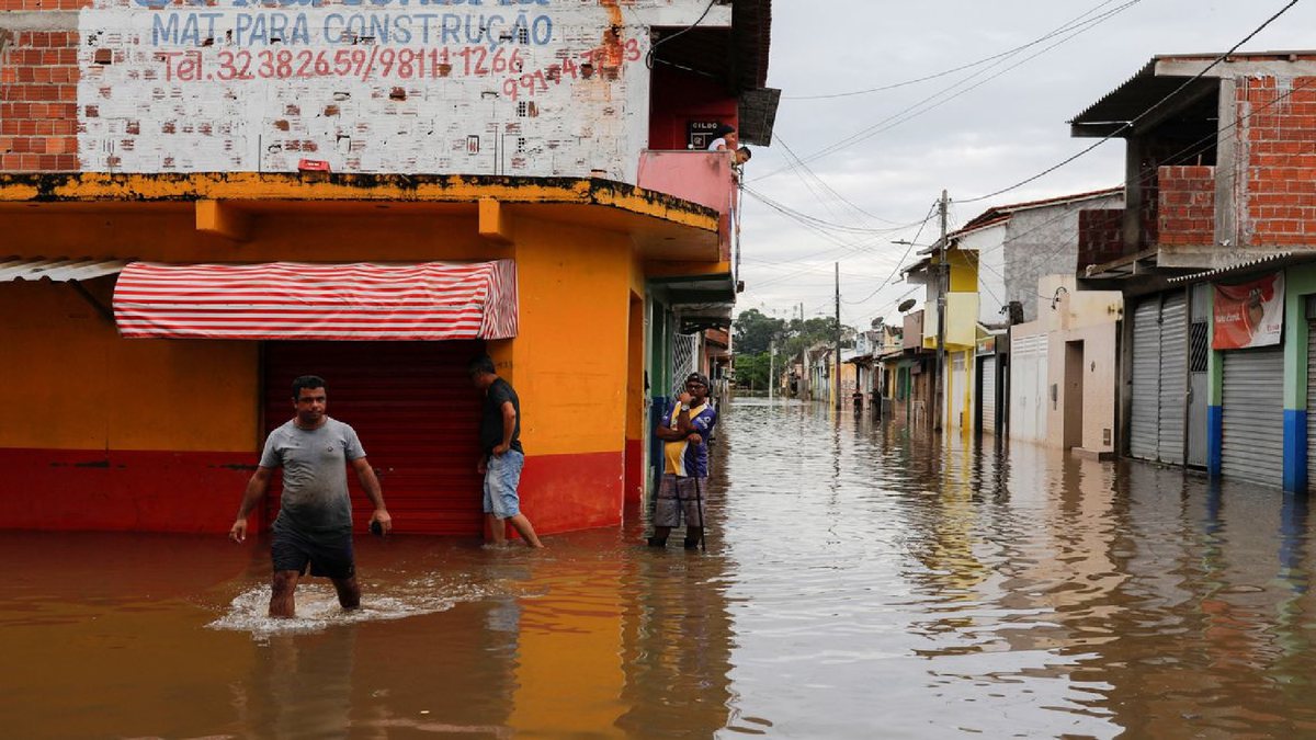 Pessoa anda em rua alagada por chuva forte - Divulgação/Agência Brasil