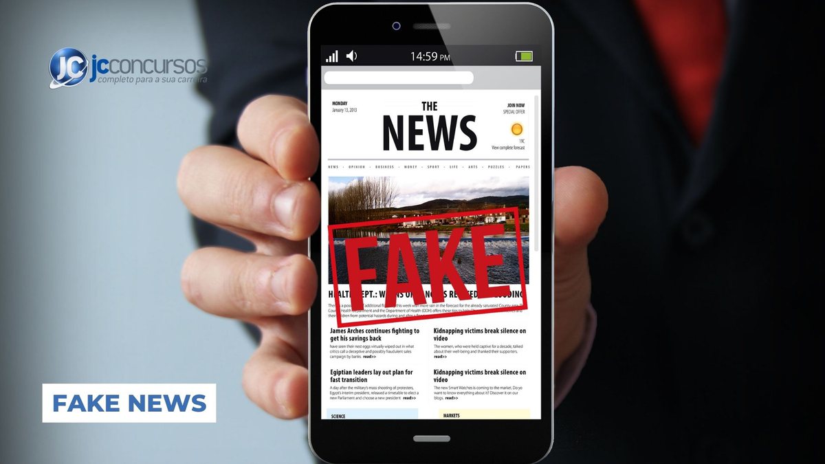 Um homem segura o celular com a tela aberta em site de notícia - Canva - Fake News