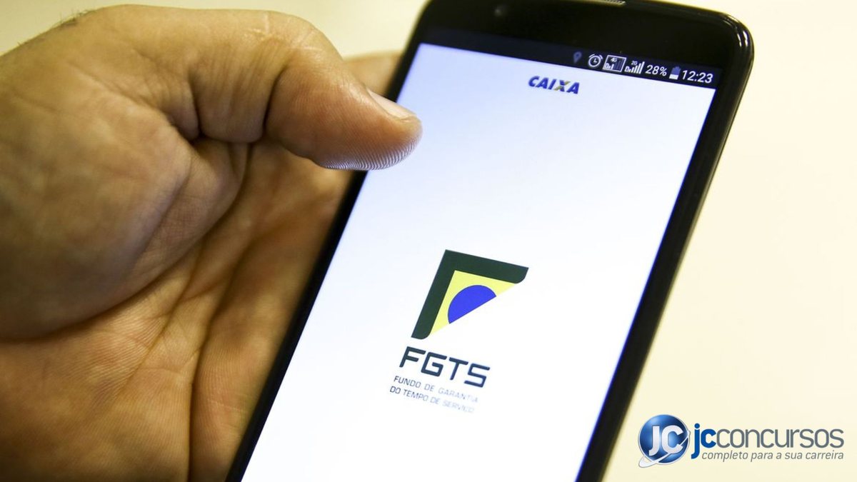 Homem segura celular aberto com aplicativo do FGTS - Agência Brasil