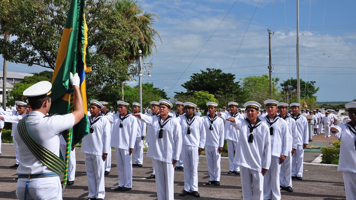 Recrutas da Marinha perfilados diante da bandeira do Brasil