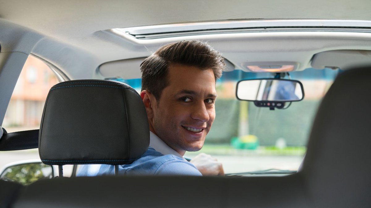 Golpe do Uber: motorista olha para o banco de trás do carro - Divulgação