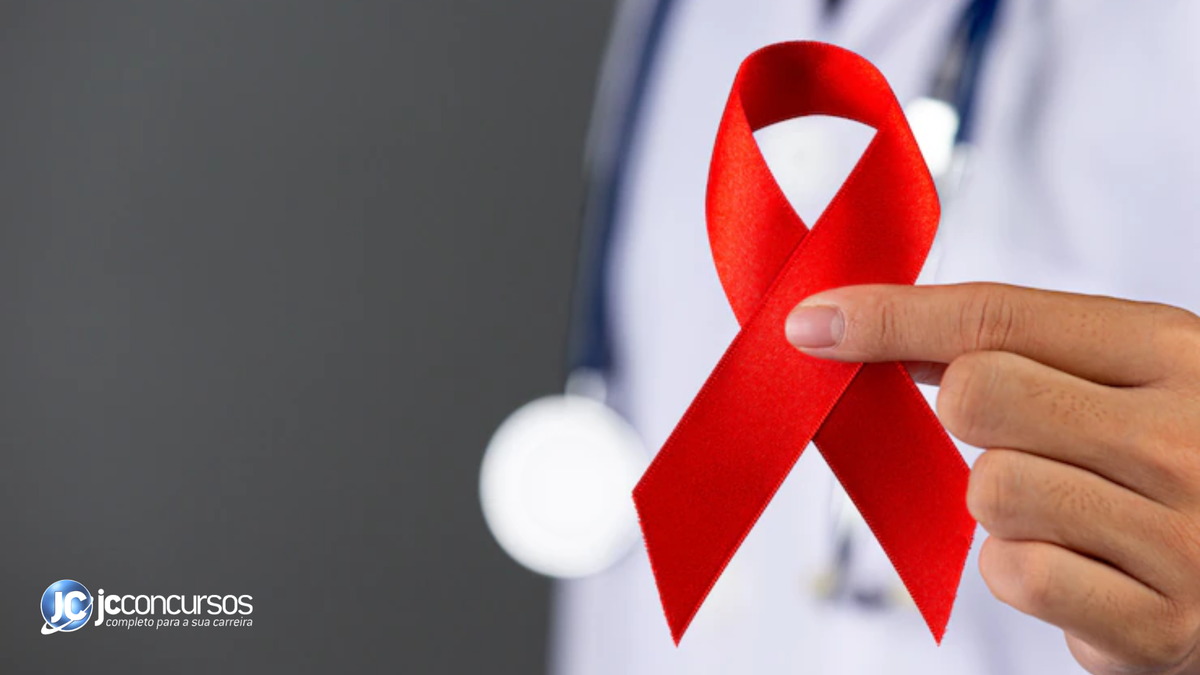 Profissional da saúde segura fita vermelha que simboliza combate à Aids