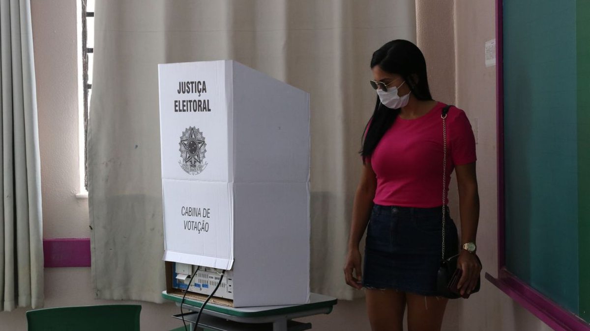 Uma mulher de frente a uma cabine de votação - Rovena Rosa/Agência Brasil - 53% das eleitoras do país são mulheres