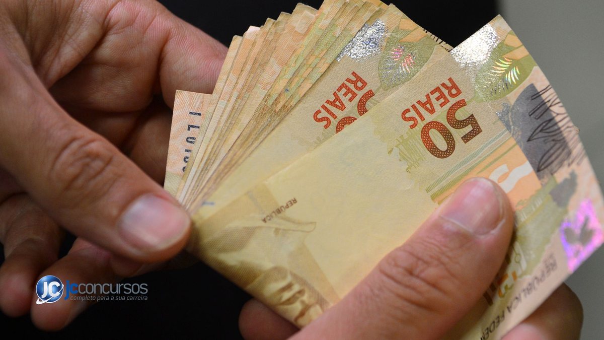 Homem segura notas de dinheiro - Agência Brasil