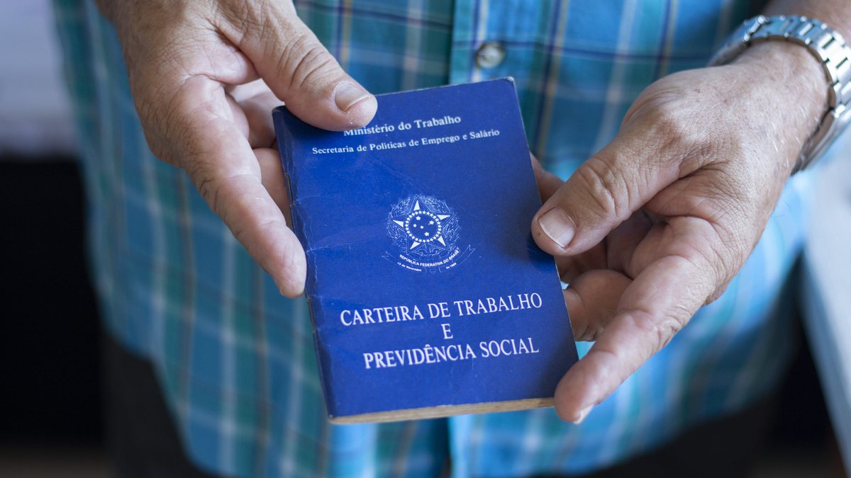 Homem segurando carteira de trabalho - Agência Brasil