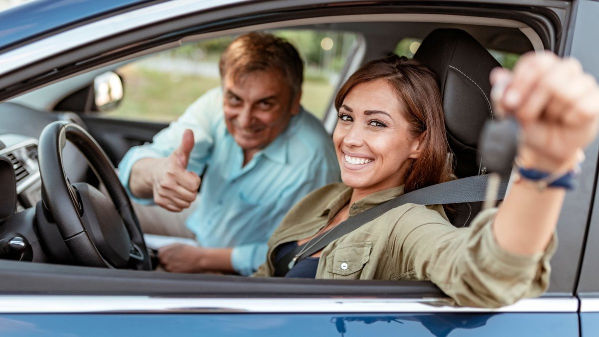 Motorista mulher sorri ao volante de carro - Divulgação