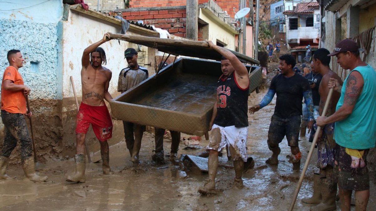 Vítimas no Litoral Norte retiram lama de via e moradores carregam cama - Divulgação/Agência Brasil