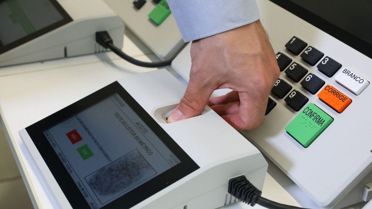 Votar em trânsito: homem coloca digital em nova urna eletrônica