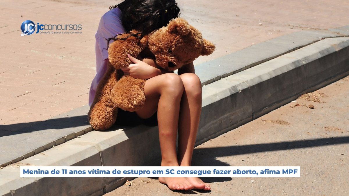 Imagem meramente ilustrativa, uma menina sentada numa calçada segura urso de pelúcia